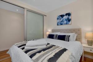 a bedroom with a large bed with a window at Sea and Park Deluxe Glenelg in Glenelg
