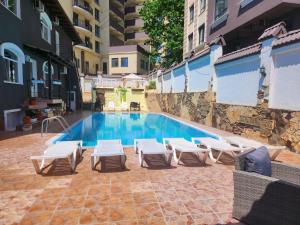 a swimming pool with lounge chairs next to a building at Shadow Hotel in Chişinău