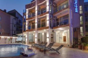 a hotel with a swimming pool in front of a building at Jupiter 1 Family Hotel in Balchik