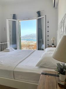 una camera da letto con un grande letto con una grande finestra di Gregos house a Andiparos