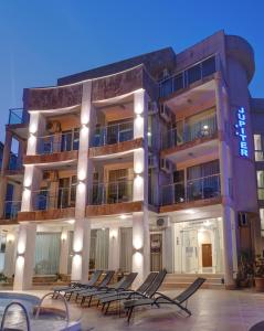 a building with chairs in front of a pool at Jupiter 1 Family Hotel in Balchik