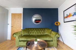 a living room with a green couch and a table at Albion at the Level - 2 BD Flat in Brighton & Hove