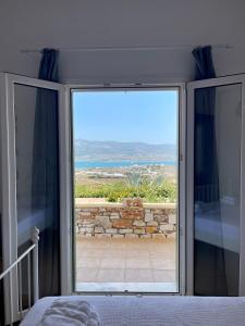 una porta scorrevole in vetro con vista sull'oceano di Gregos house a Andiparos