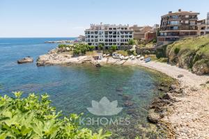 a view of a beach with buildings and the ocean at Villa Lidia in L'Escala