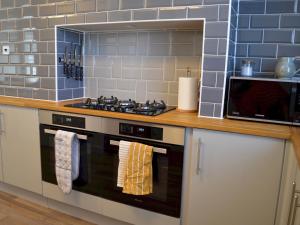 een keuken met een fornuis en een magnetron bij Pass the Keys Gorgeous Maisonette in Bournemouth