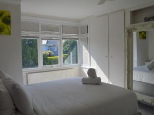 een witte slaapkamer met een bed en een raam bij Pass the Keys Gorgeous Maisonette in Bournemouth
