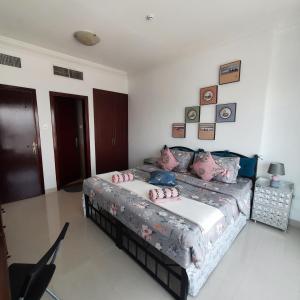 1 dormitorio con 1 cama con almohadas rosas en Beach side Private Room for Travelers, en Sharjah