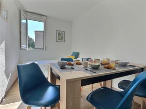 comedor con mesa y sillas azules en Tout Inclus - Plein Centre - Netflix - Moontown, en Lunéville