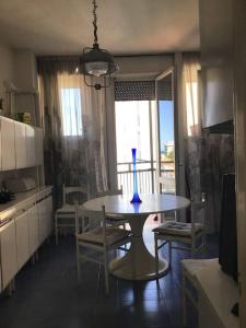 une cuisine avec une table et un vase bleu. dans l'établissement Appartamento panoramico centro, à Riccione