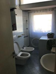La salle de bains est pourvue de toilettes, de 2 lavabos et d'une fenêtre. dans l'établissement Appartamento panoramico centro, à Riccione