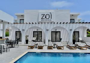 a resort with a pool and chairs and a building at Zoi Ayia Napa in Ayia Napa