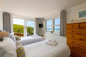 a bedroom with two beds and a window at Beachcombers Apartments in Newquay