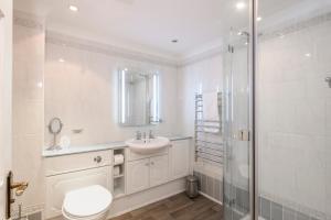 a bathroom with a toilet and a sink and a shower at Beachcombers Apartments in Newquay