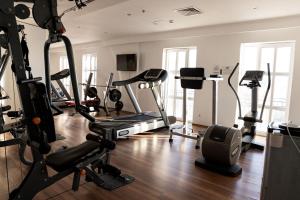 a gym with treadmills and exercise equipment in a room at Chagala Aktau Hotel in Aktau