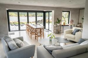 a living room with a couch and a table and chairs at Plockton Shoreside House in Plockton
