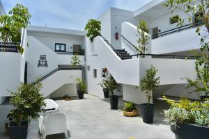 a courtyard with potted plants and stairs in a building at Zoi Ayia Napa in Ayia Napa