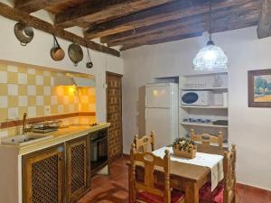 uma cozinha com uma mesa e um frigorífico em Casa rural Álamo - Valle de El Paular em Rascafría