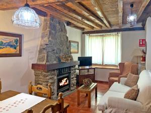 salon z kamiennym kominkiem i kanapą w obiekcie Casa rural Álamo - Valle de El Paular w mieście Rascafría