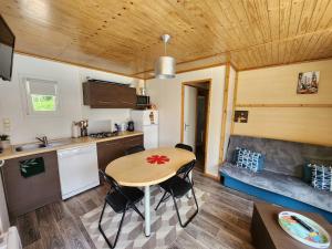 a kitchen and a table in a tiny house at Le clos de lignac in Cieux