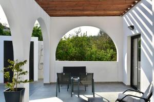 a patio with a table and chairs and an archway at Zoi Ayia Napa in Ayia Napa