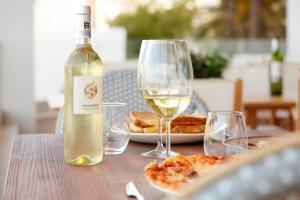 Una botella de vino blanco y dos copas en una mesa. en Catalonia Mirador des Port, en Mahón