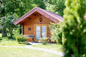 eine Holzhütte mit einer Bank in einem Park in der Unterkunft Kummerower Hof in Neuzelle