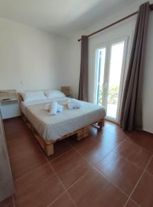 a bedroom with a bed and a large window at Lighthouse View Syros in Azolimnos Syros