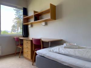 BORG Sommerhotell في Spjelkavik: غرفة نوم مع مكتب وسرير ومكتب