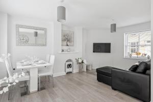 a living room with a black couch and a table at Beach Front House in Walton-on-the-Naze