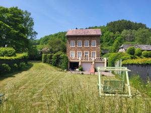 une maison avec une aire de jeux en face d'une cour dans l'établissement Die Alte Schule app, à Saint-Vith