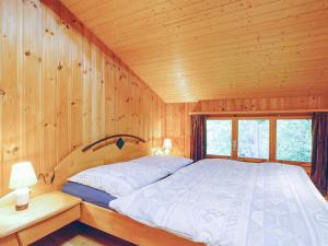 ein Schlafzimmer mit einem Bett in einer Holzhütte in der Unterkunft Chalet mit Saunabereich - CH 383.014 in Nendaz