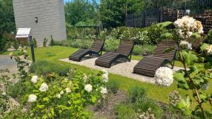 a row of benches in a garden with flowers at Old Town Nadmotławie - Sauna & Gym I 10min deptak in Gdańsk