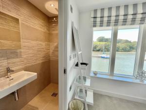 ein Badezimmer mit einer Leiter neben einem Waschbecken und einem Fenster in der Unterkunft 1 The Boatyard - Water fronted, town location & parking for 2 cars in Kingsbridge + 22 Fotos