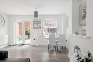 a white living room with a table and chairs at Beach Front House in Walton-on-the-Naze