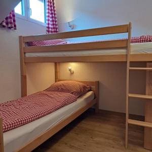 1 Schlafzimmer mit 2 Etagenbetten und einer Leiter in der Unterkunft Faltenbach Ferienwohnungen in Oberstdorf in Oberstdorf