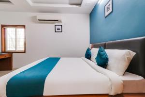 a bedroom with a large bed with blue walls at Hotel Stay Inn Maharani Peta in Alipur