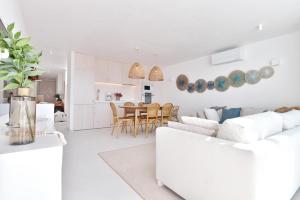 ein weißes Wohnzimmer mit einem Sofa und einem Tisch in der Unterkunft Casas de Sal in Fuseta