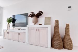 a kitchen with a white cabinet and two vases at Casas de Sal in Fuzeta