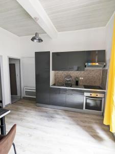 eine Küche mit Küchengeräten aus Edelstahl in einem Zimmer in der Unterkunft Le Saint Jean Cosy et Confort in Villefranche-de-Conflent