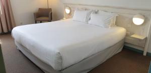 a large white bed in a hotel room at Thalacap Île de Ré - Thalasso & Spa in Ars-en-Ré