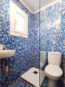 a blue tiled bathroom with a toilet and a sink at Acogedor Apartamento en Barcelona Forum Sant Adrià in Sant Adria de Besos
