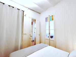 um quarto branco com uma cama e uma janela em Acogedor Apartamento en Barcelona Forum Sant Adrià em Sant Adria de Besos