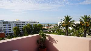 艾西拉的住宿－hotel azayla，阳台享有棕榈树的城市美景。