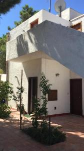 Casa Vacanze Residence Baia Fenicia Vulcano, Isole Eolie في La Fabbrica: مبنى أبيض صغير بسقف كبير