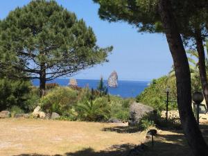 Casa Vacanze Residence Baia Fenicia Vulcano, Isole Eolie في La Fabbrica: إطلالة على المحيط من حديقة بها أشجار