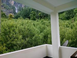 a balcony with a view of a waterfall at Cabin in the Woods in Vashisht