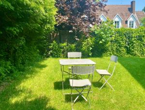 two chairs and a table in the grass at IZBA BnB in Roubaix