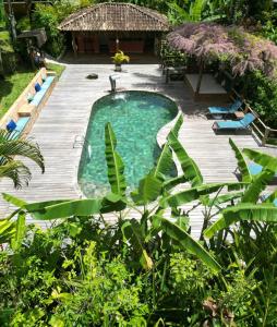 a swimming pool in a yard with a wooden deck at Pousada do Bosque in Trancoso