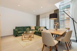 a living room with a green couch and a table at Fahana Las Canteras in Las Palmas de Gran Canaria