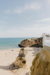 a beach with people on the sand and the ocean at Home Santa Clara in Albufeira